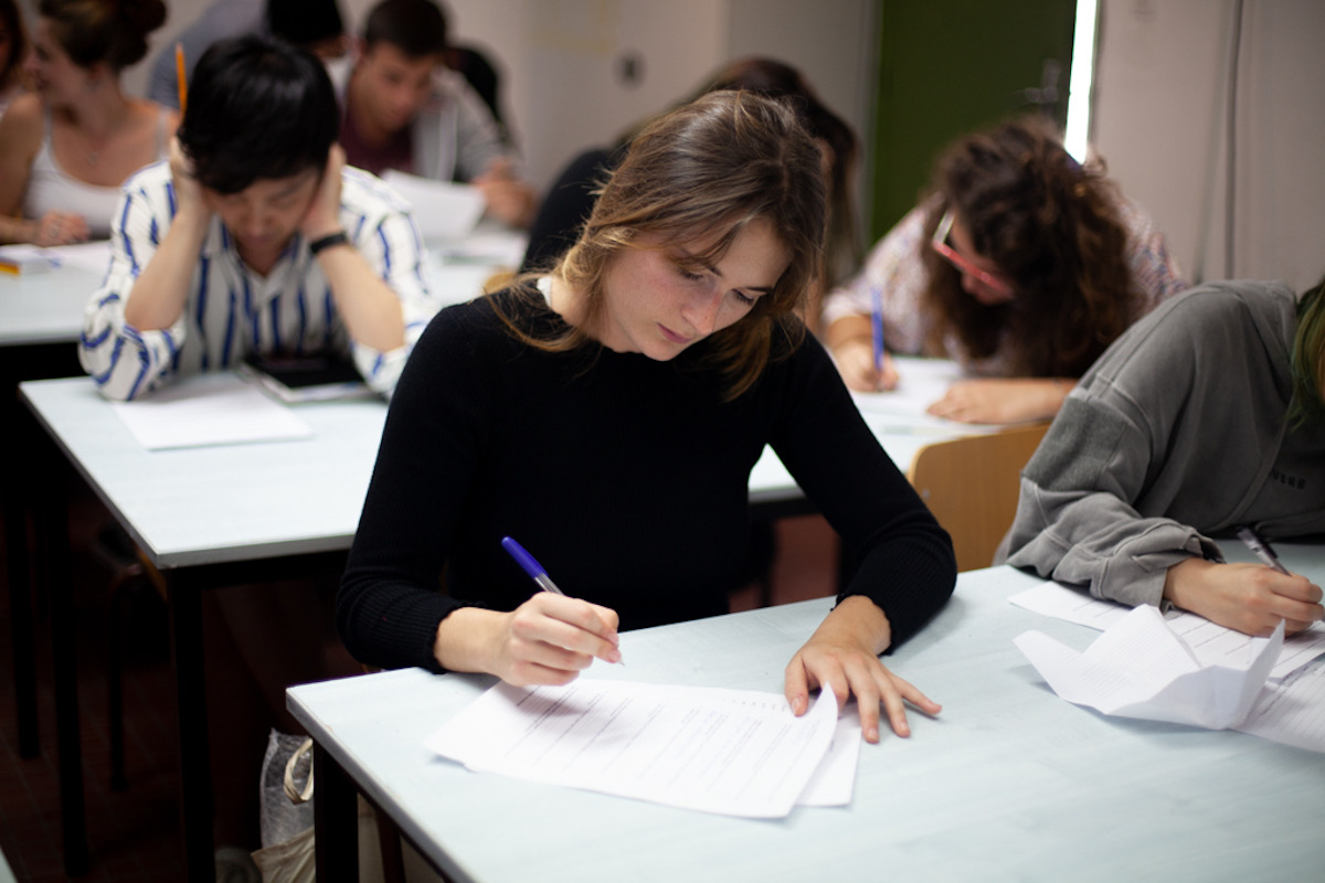 A student focused on a written exam in a classroom